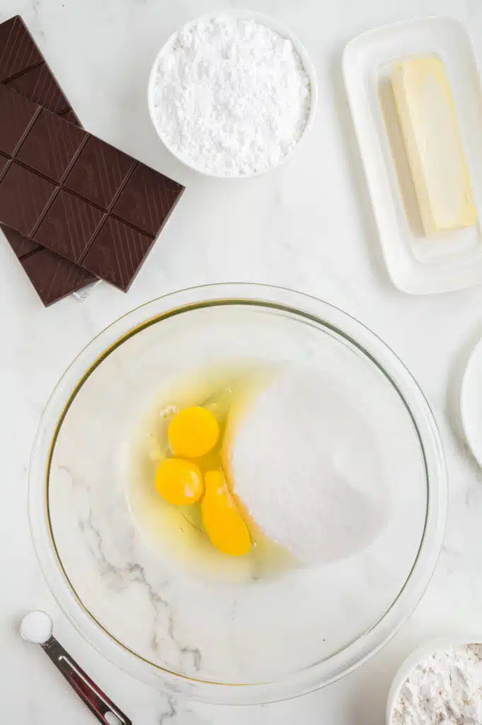 process shot making cheesecake brownies, whisk eggs and sugar together.