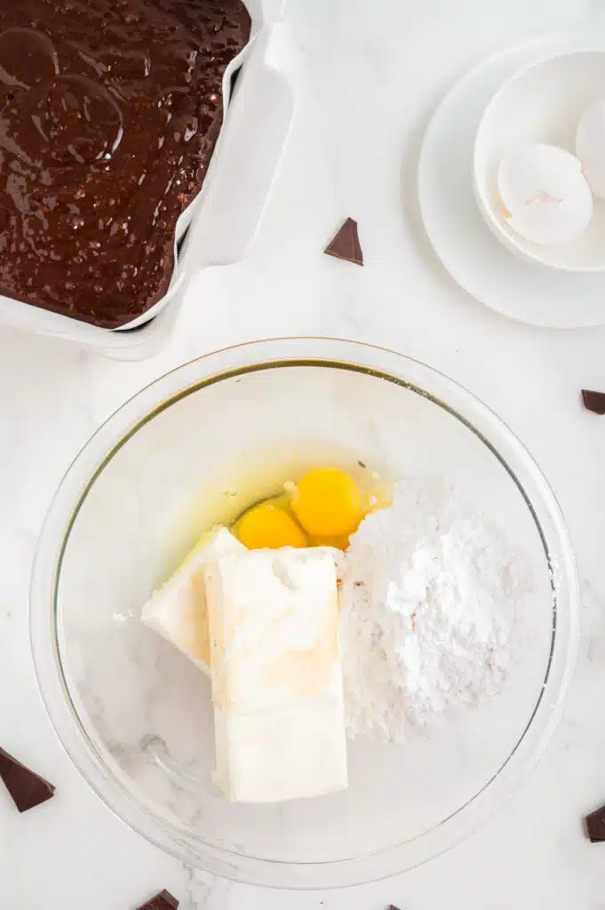 Mixing together all the ingredients to make cheesecake layer of cheesecake brownies.