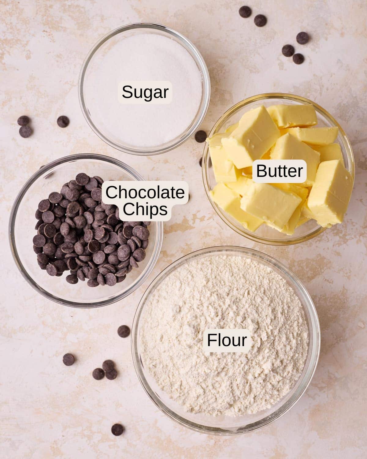 Ingredients to make chocolate chip shortbread cookies - sugar, butter, flour, and chocolate chips.