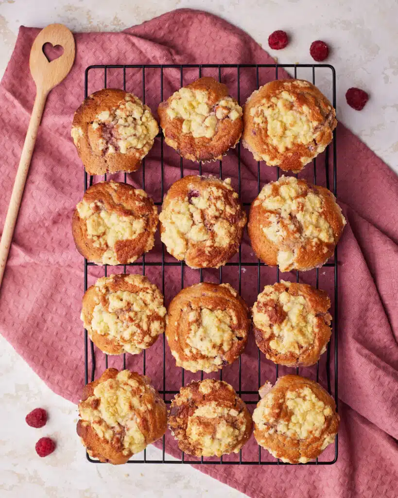 Baked raspberry muffins on a cooling rack.
