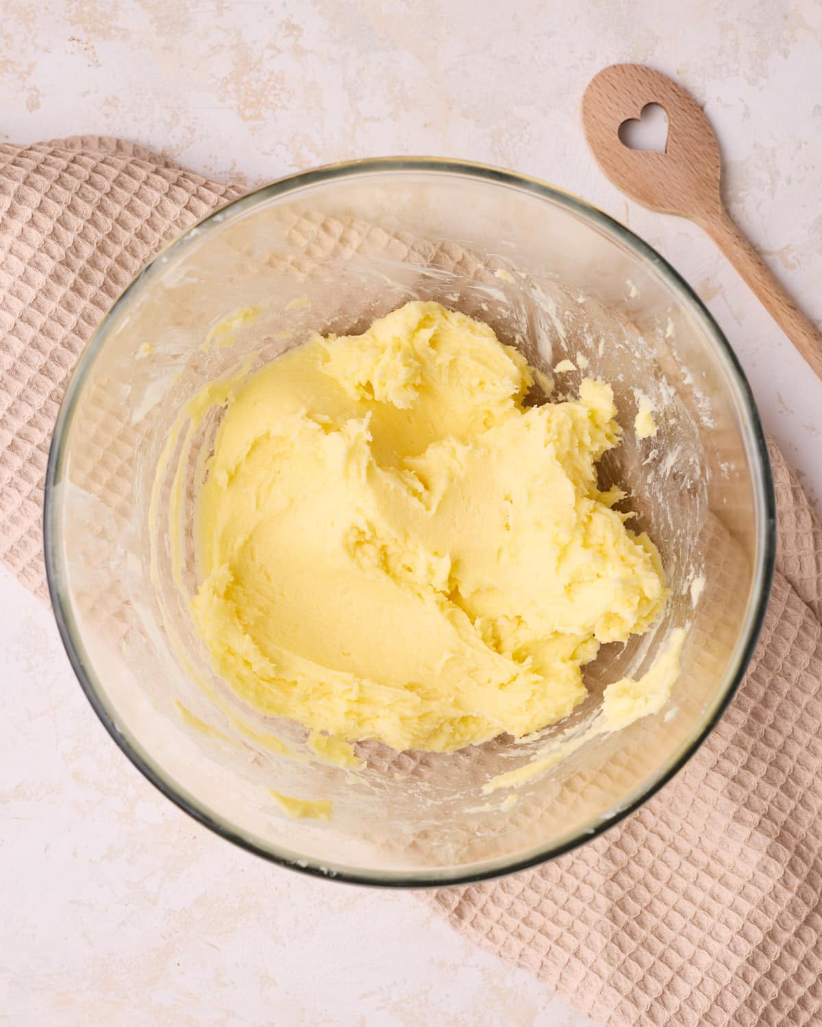 Blending softened butter and sugar together in a glass bowl to make shortbread dough.
