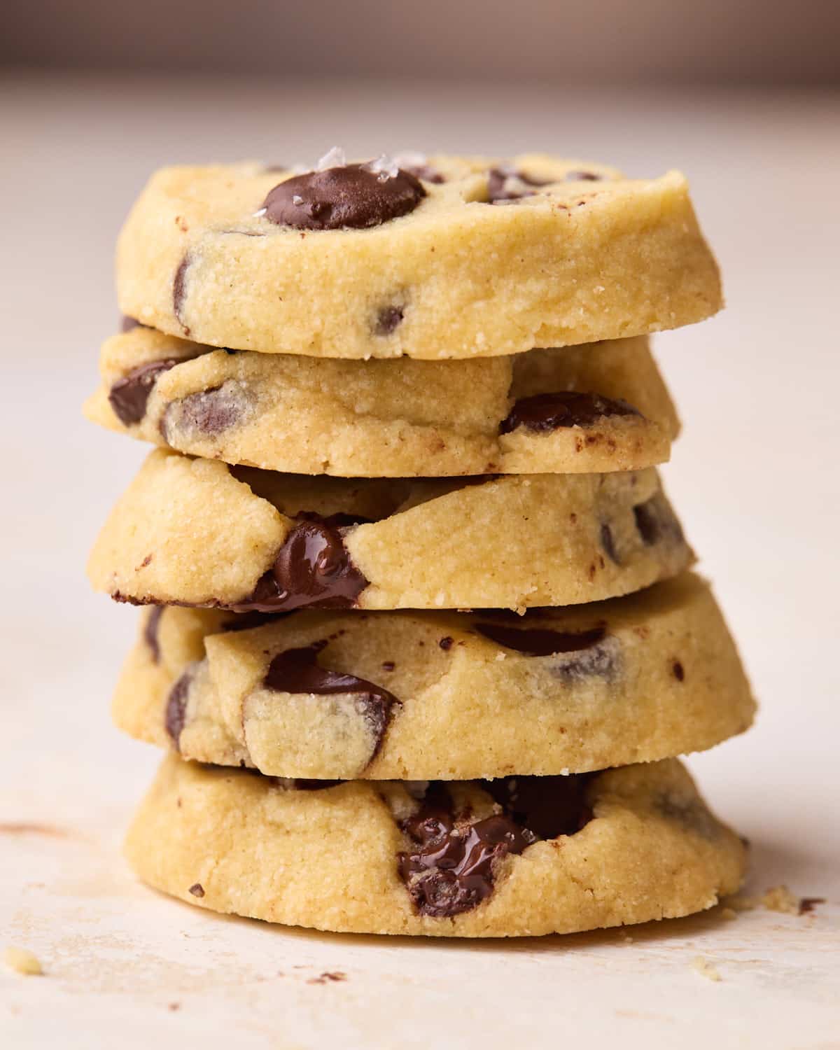 A stack of five round chocolate chip shortbread cookies.