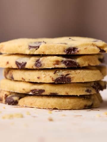 A stack of five heart shaped chocolate chip shortbread cookies on top of each other.