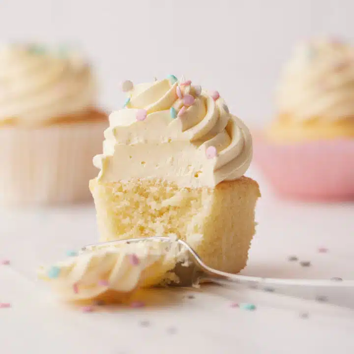 Vanilla cupcake with a forkful taken out to show tender crumb.