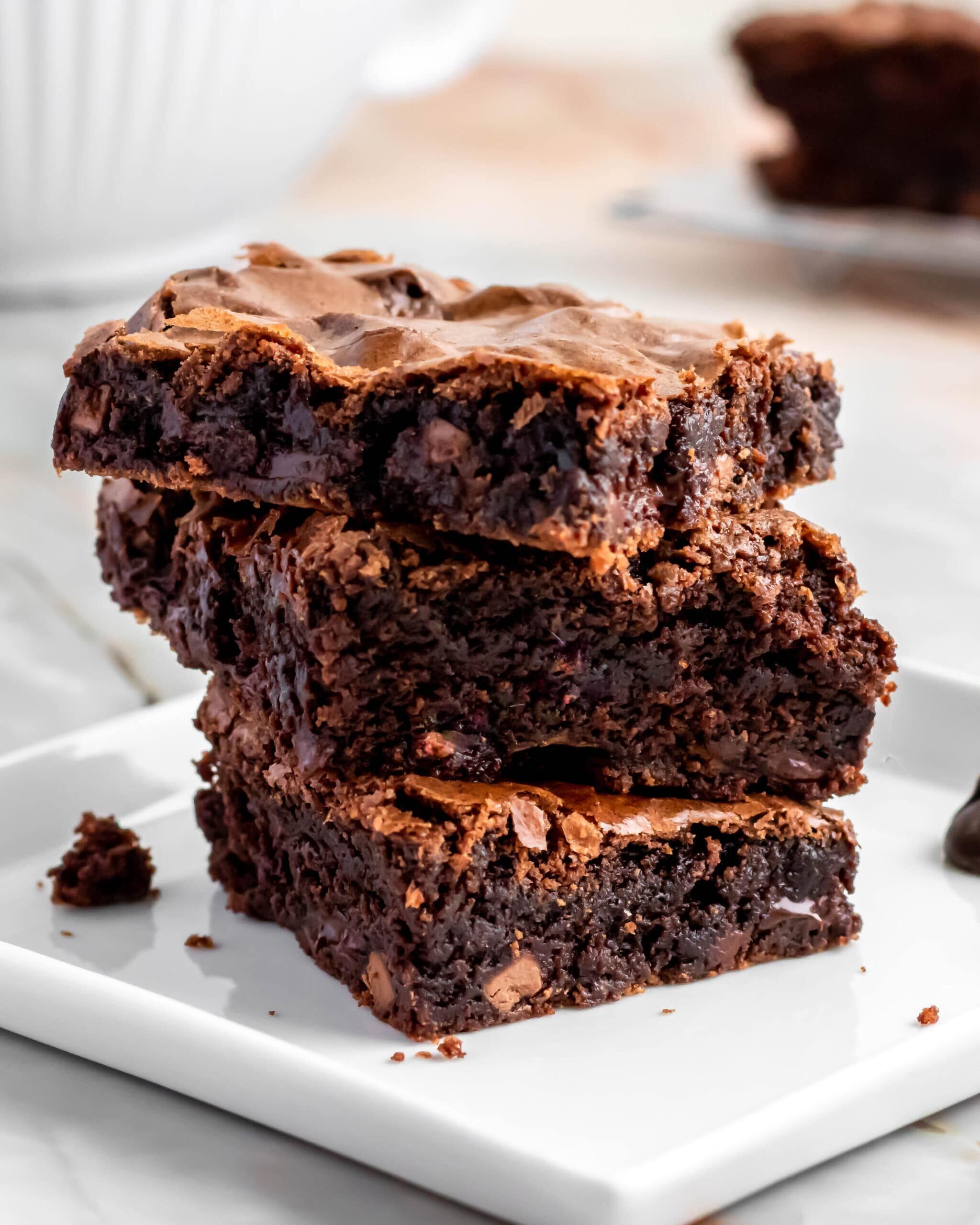 Three stacked ultimate chocolate brownies up close showing the chocolate filled insides.