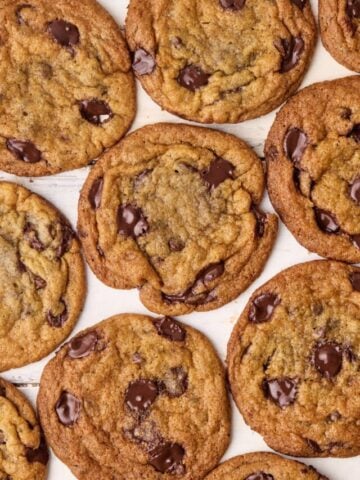 Brown butter chocolate chips cookies lying flat, side by side on a table.