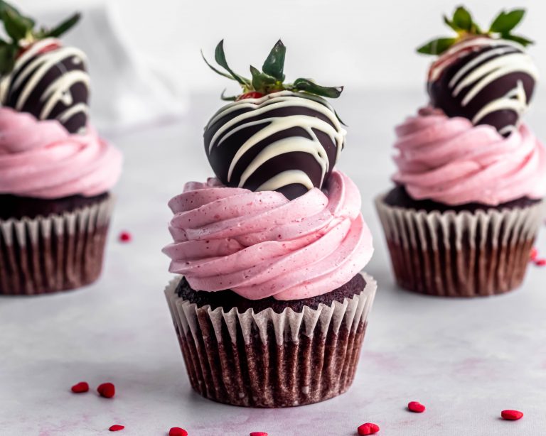 chocolate cupcake with strawberry italian meringue buttercrem and a chocolate dipped strawberry on top