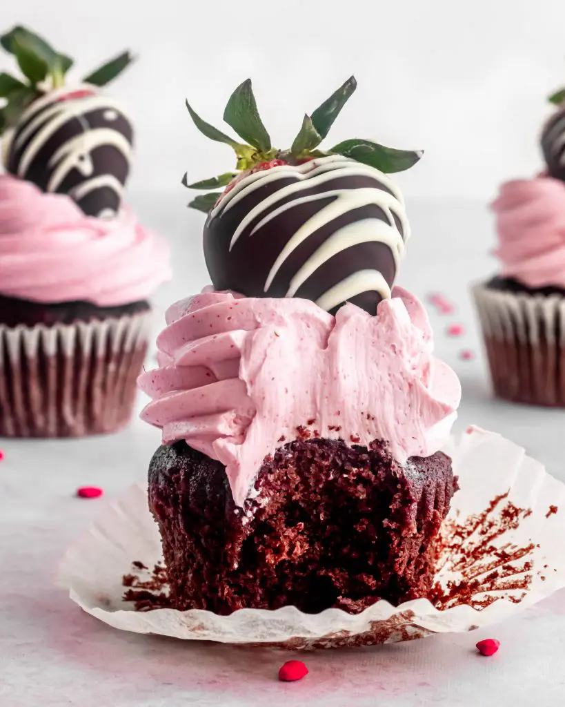 chocolate and strawberry cupcake with strawberry italian meringue buttercrem and a chocolate dipped strawberry on top