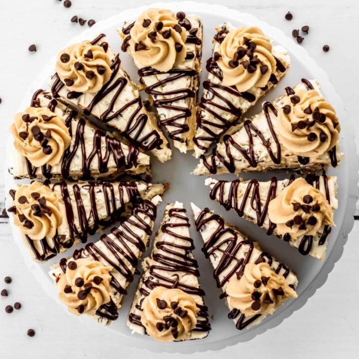 Cookie dough cheesecake from above, cut into slices with ganache drizzled on top and a swirl of cookie dough frosting.