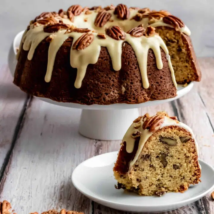 maple pecan bundt cake with maple cream cheese glaze and candied pecans on top.