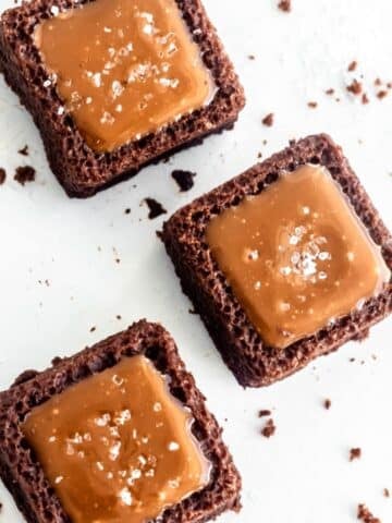 Three chocolate and caramel bites, viewed from above, with a sprinkling of salt on top of each one.