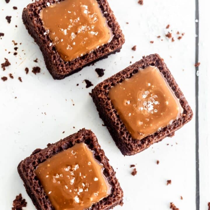 Three chocolate and caramel bites, viewed from above, with a sprinkling of salt on top of each one.