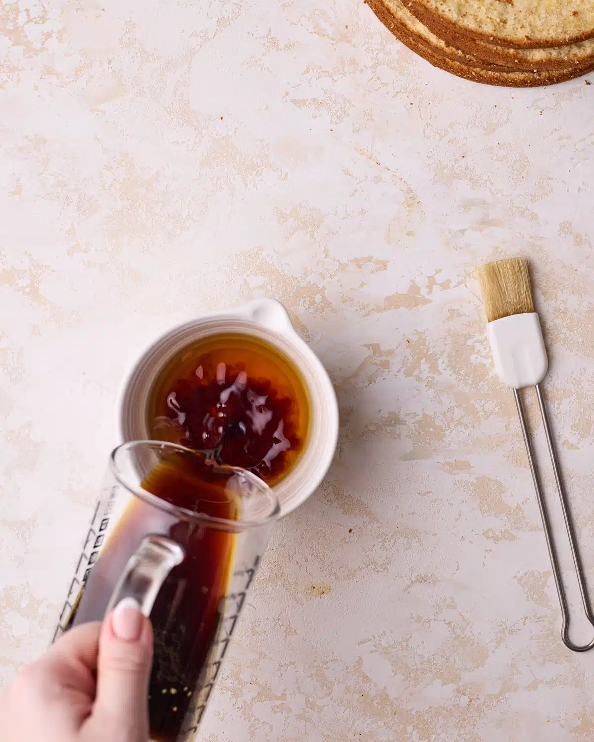 Mixing fresh espresso with amaretto to make a coffee soak for tiramisu cake.