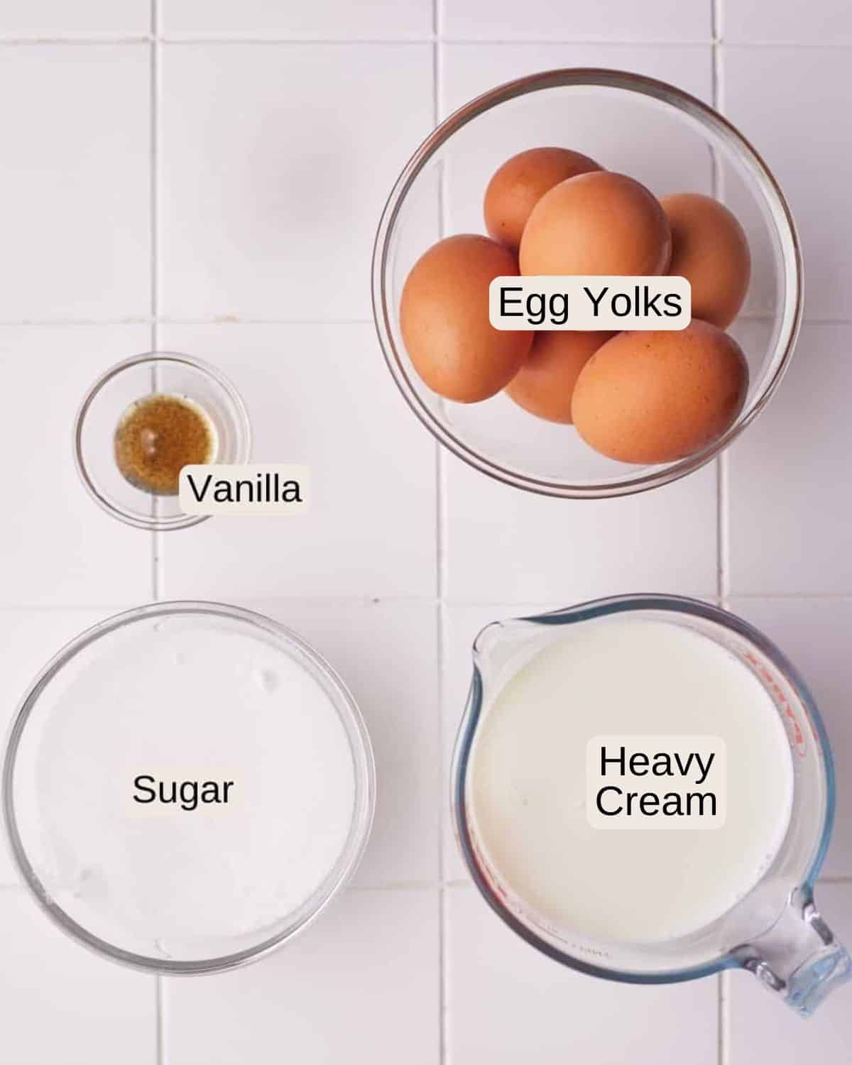 Creme brulee ingredients including egg yolks, sugar, vanilla bean paste and heavy cream (double cream).