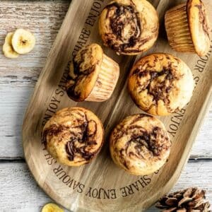 Nutella stuffed banana muffins viewed from the top down, on a cutting board.