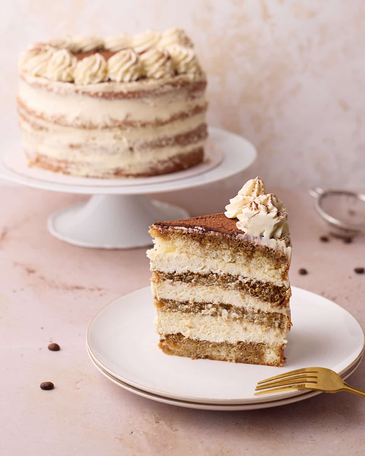 Tiramisu cake with a slice taken out of it to show the distinct layers.