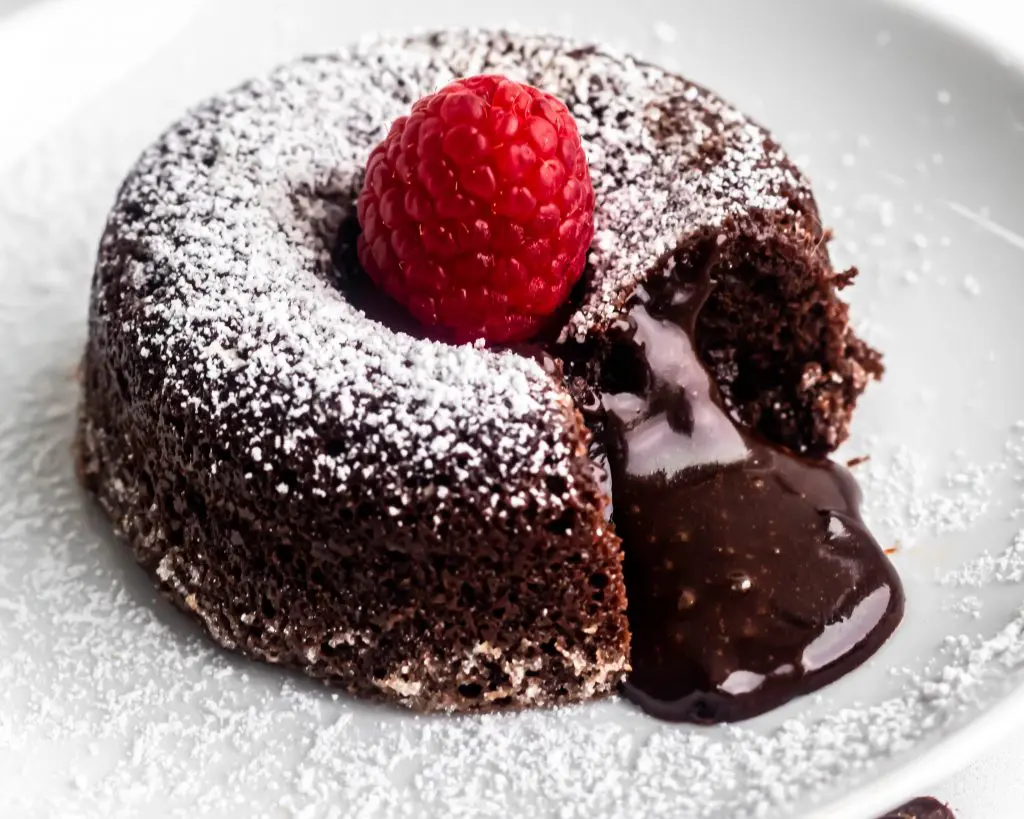 Close up of the molten chocolate lava cake with melty middle pouring out.