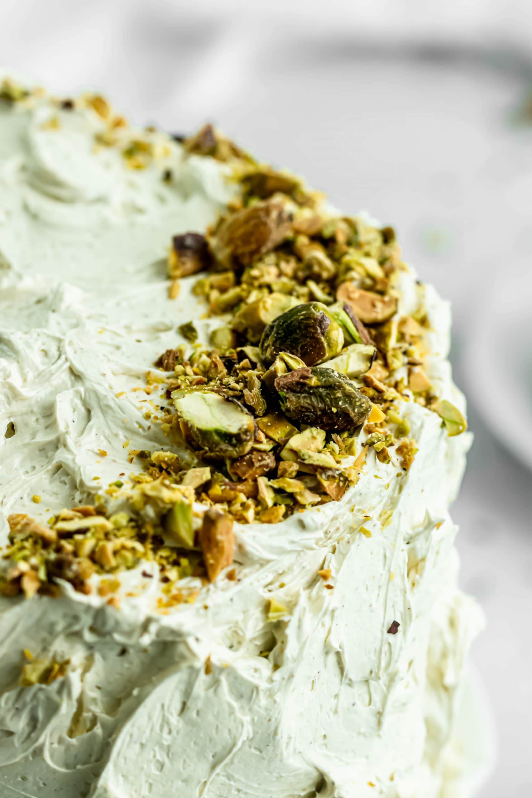 close up of chopped pistachios on pistachio cake.