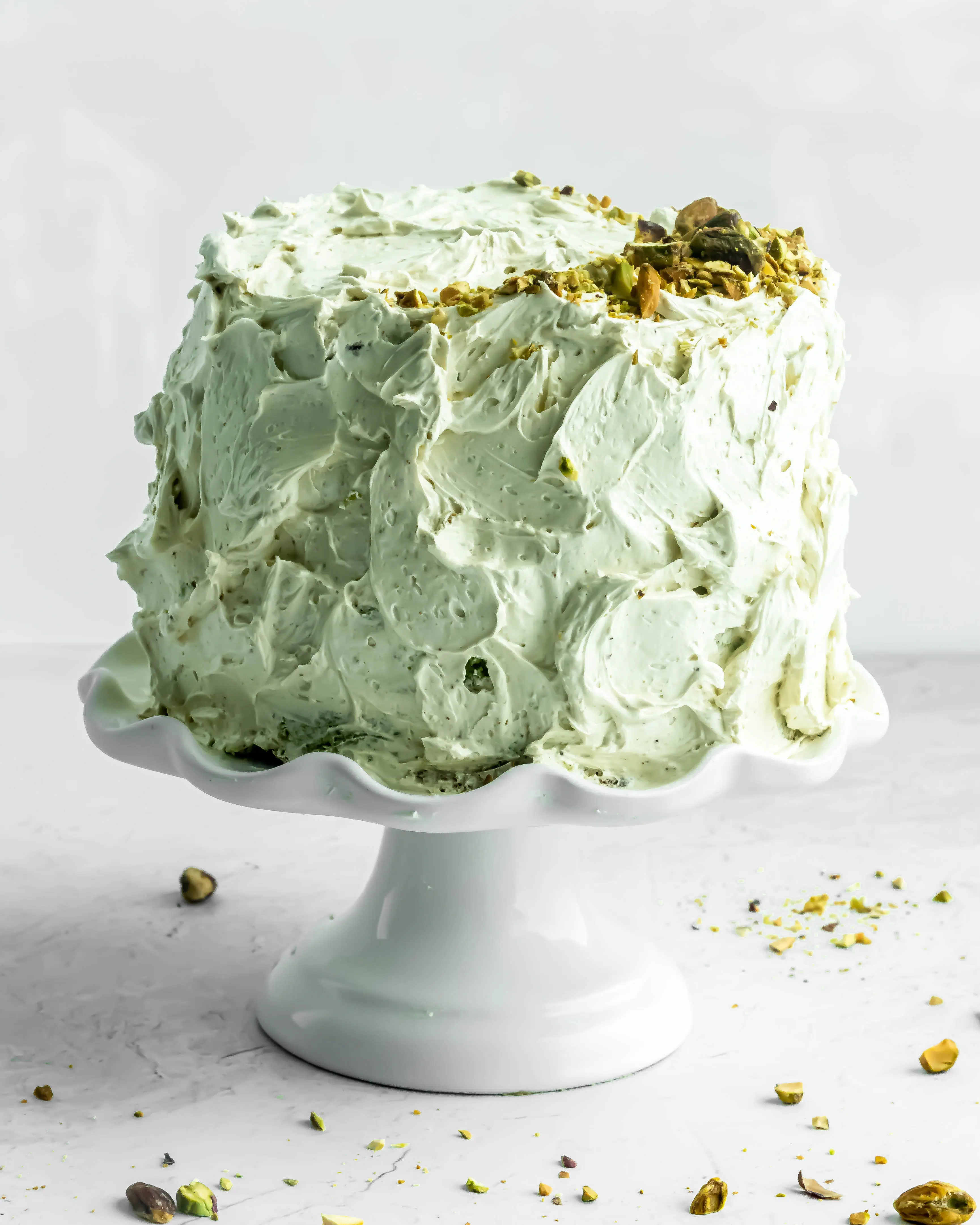 pistachio cake covered in pistachio italian meringue buttercream.