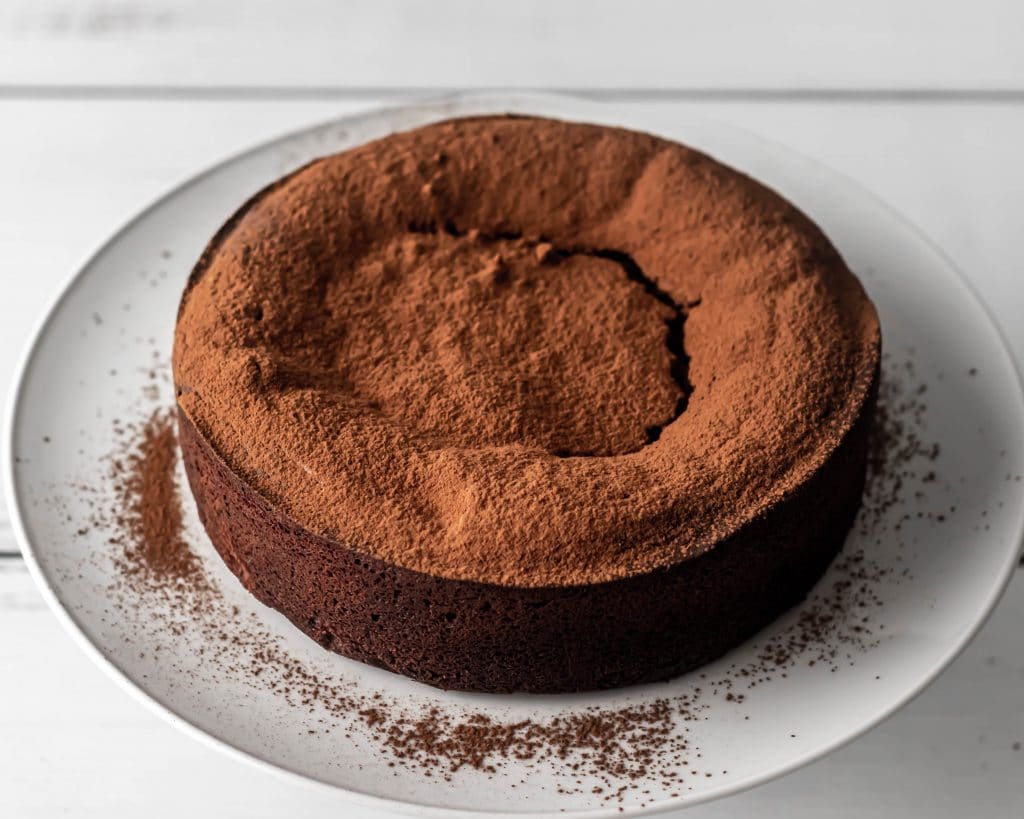whole chocolate torte with cocoa powder dusted on top