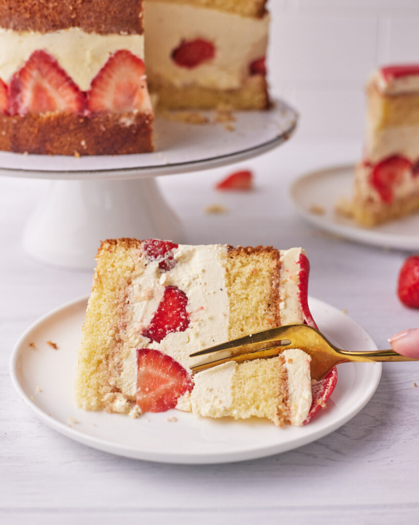 slice of fraisier cake made with genoise sponge being cut into with a fork. 