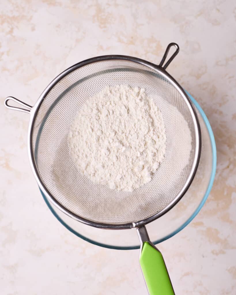 Sifting dry ingredients together to make sponge cake.