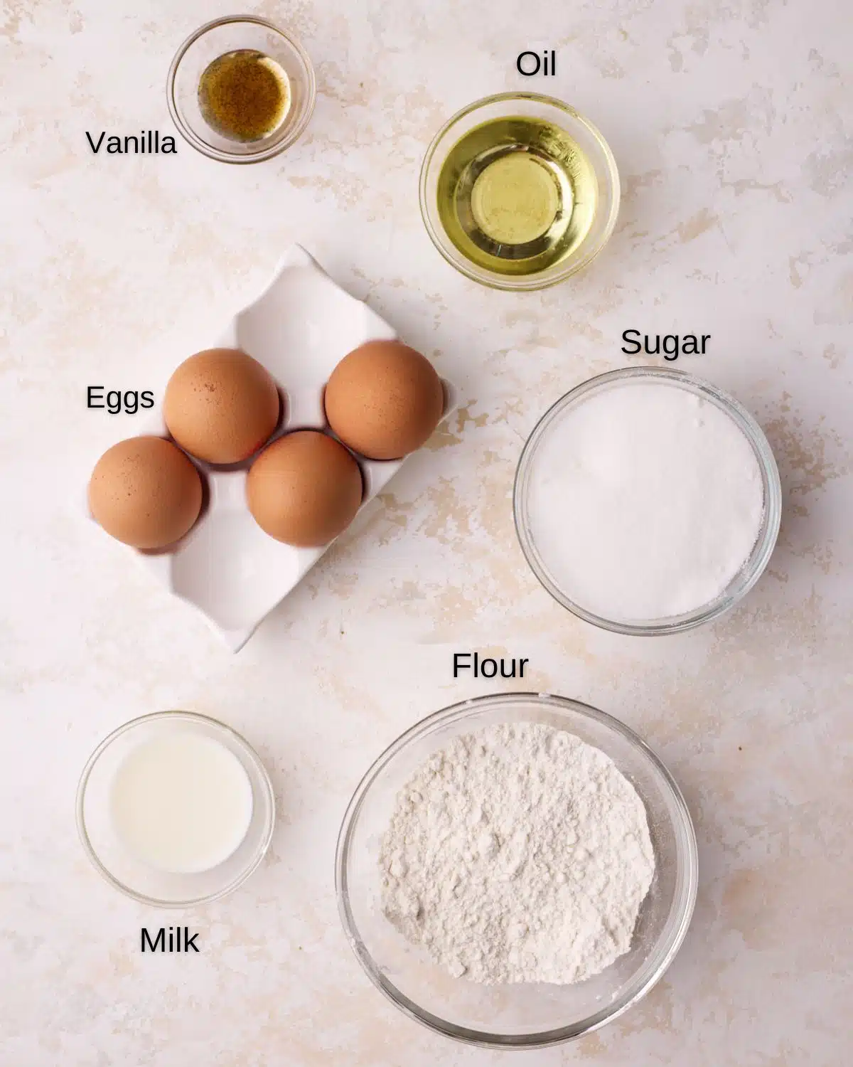 Ingredients to make genoise sponge cake, eggs, sugar, oil, flour and vanilla. 