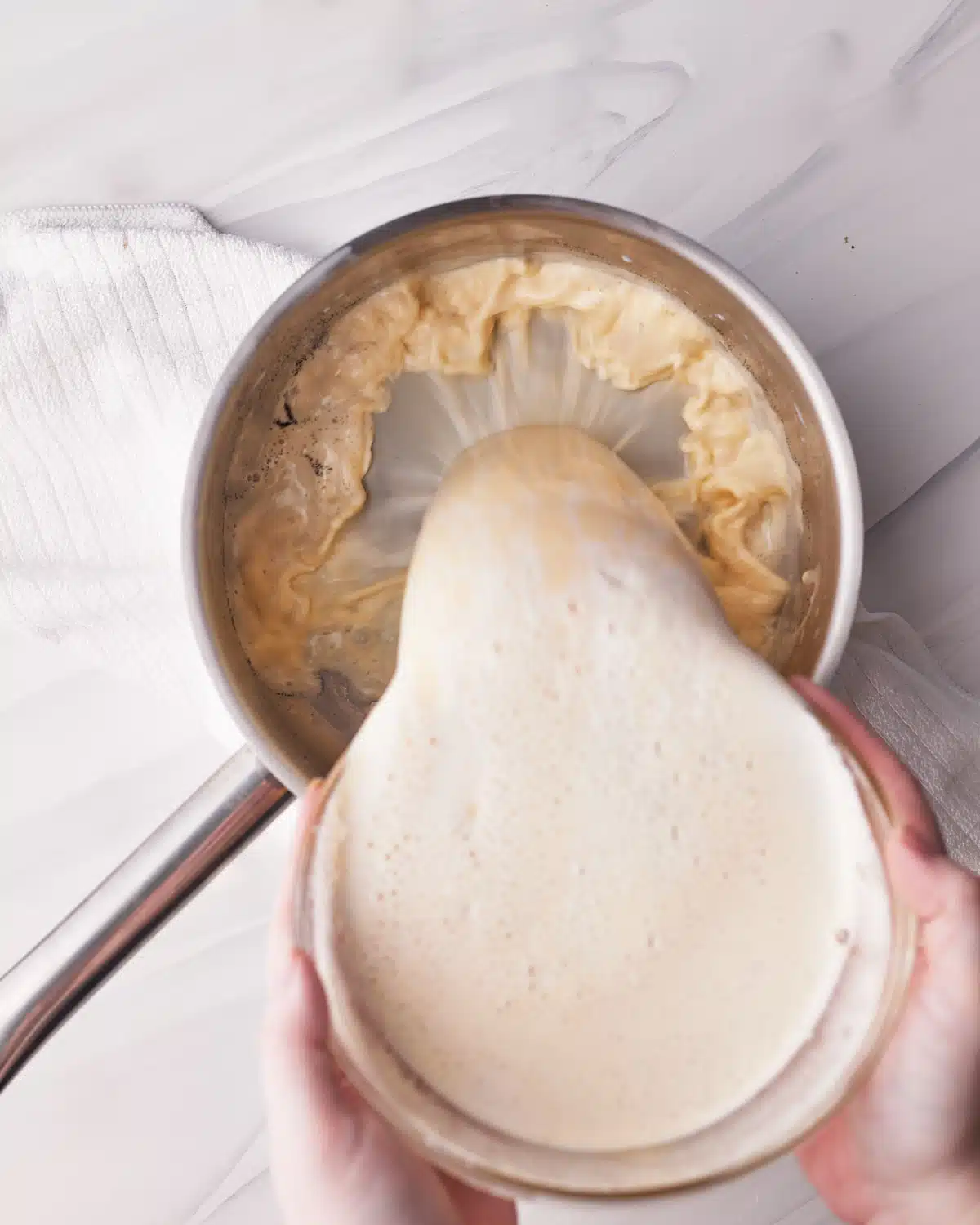 Pouring creme patissier mixture back into saucepan.