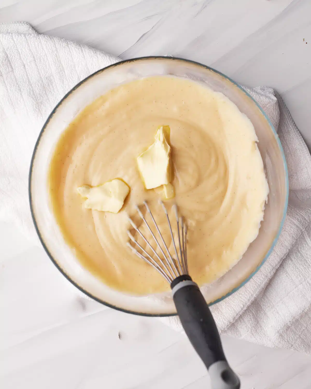 Whisking butter into pastry cream, one small chunk at a time. 