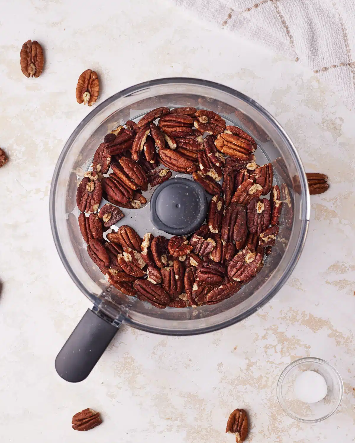 Toasted pecans in a food processor ready to be turned into pecan butter. 