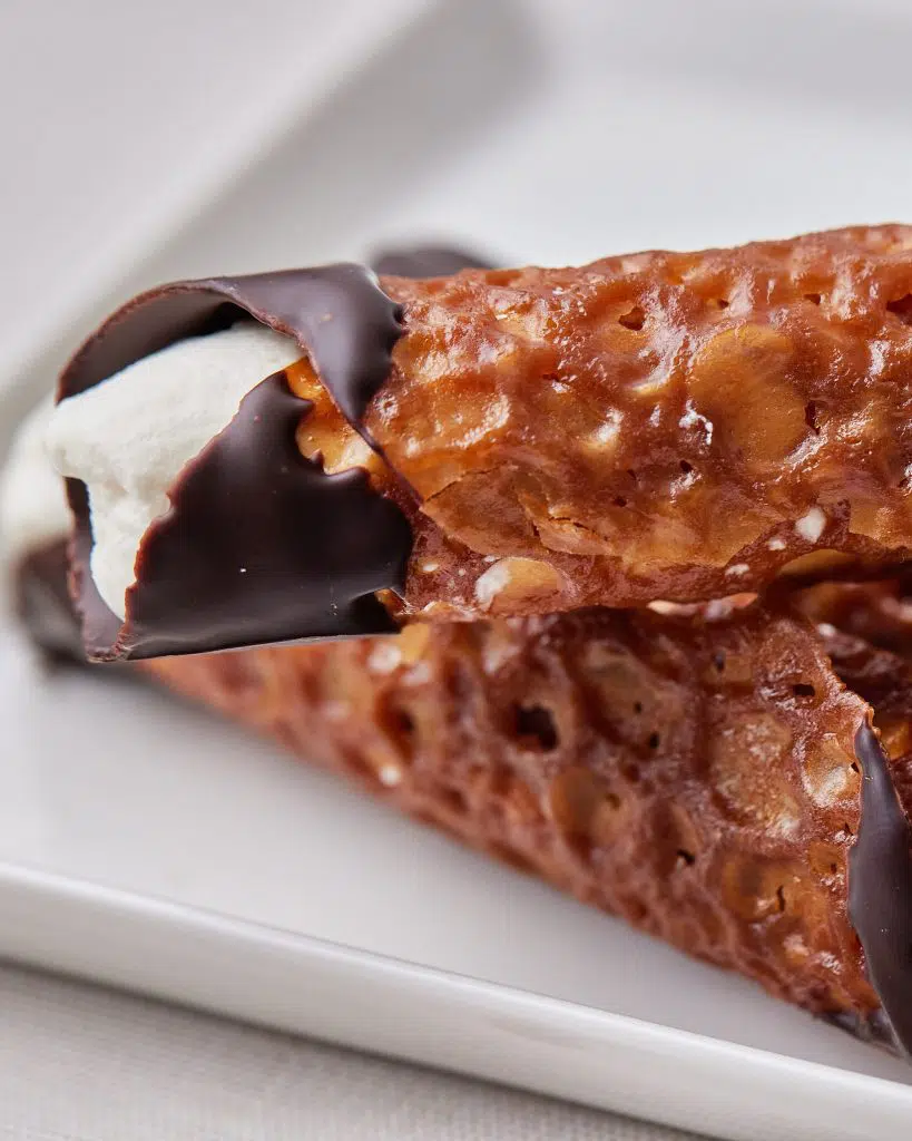 Close up of brandy snaps with amaretto cream, dipped in chocolate