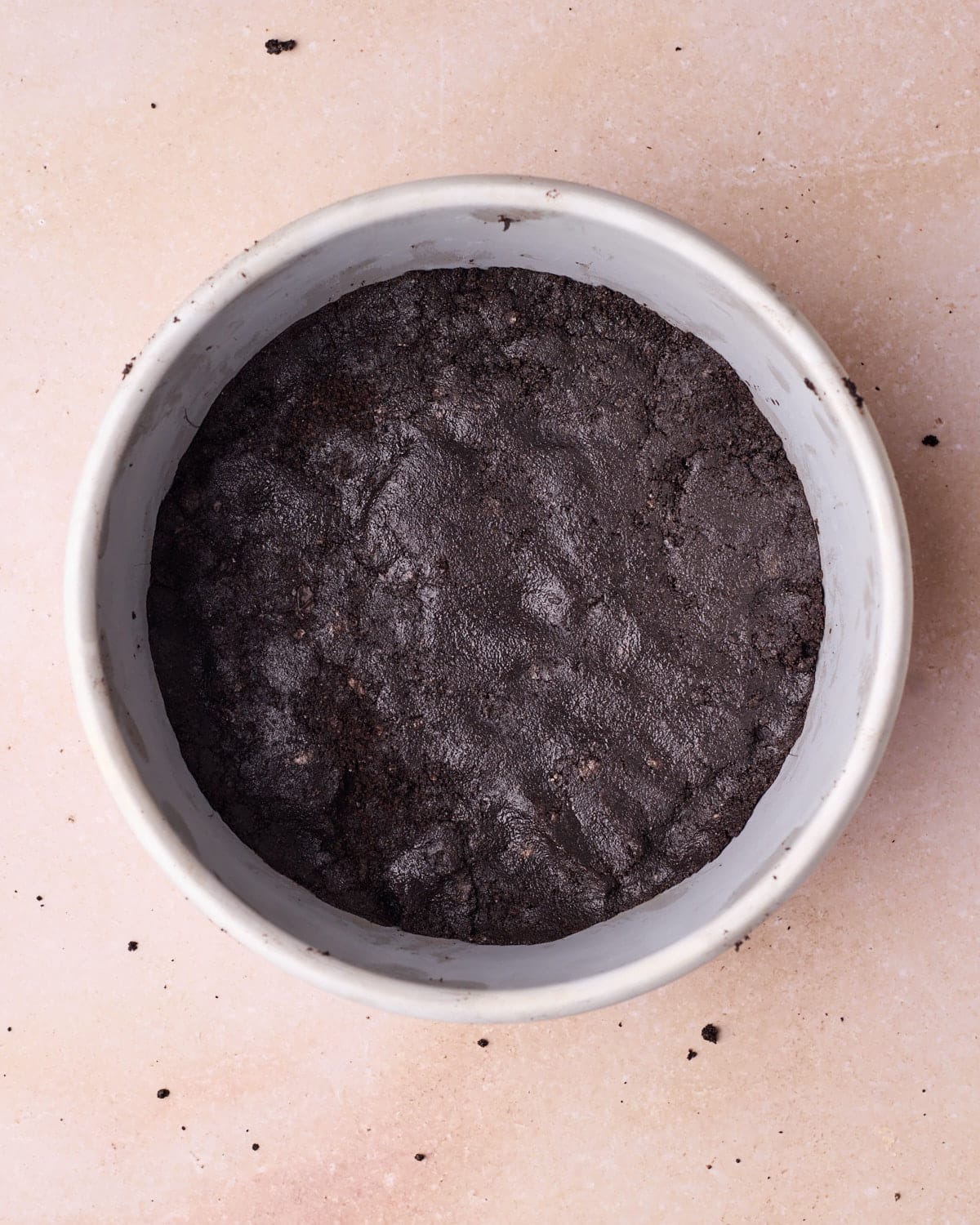 Oreo crust pressed into the bottom of a losse-bottomed cake pan.