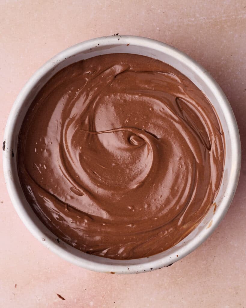 Chocolate cheesecake batter in a cake pan, before baking.