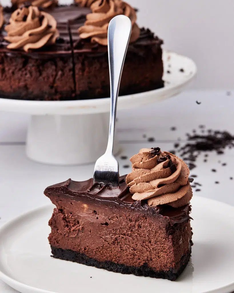 slice of chocolate cheesecake with a dessert fork sticking out the top