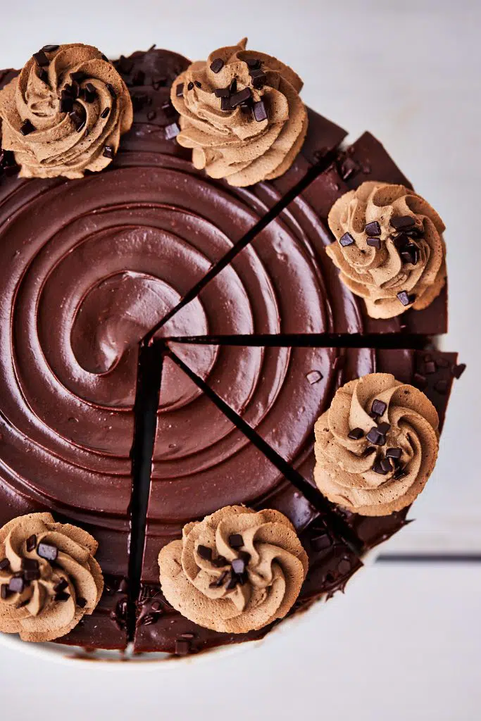 Whole chocolate cheesecake with three slices slightly moved out