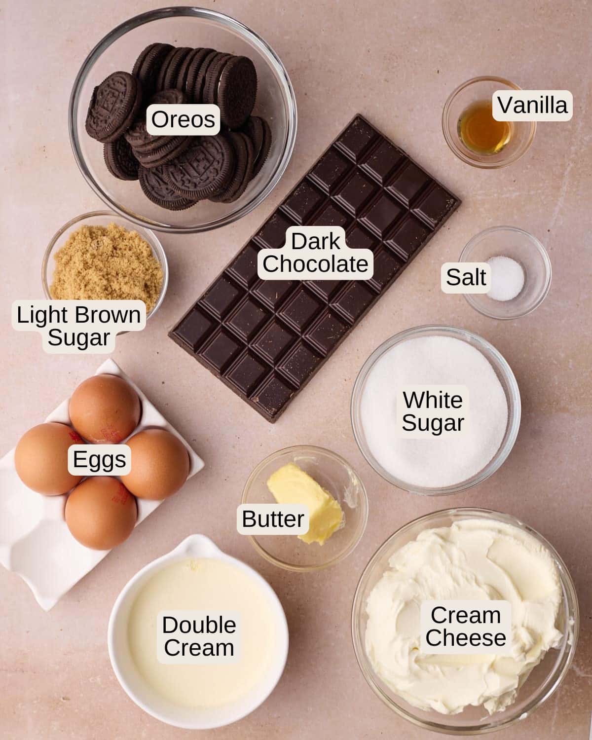 Ingredients to make chocolate cheesecake - including cream cheese, white sugar, light brown sugar, eggs, vanilla, salt, dark chocolate, and heavy cream.