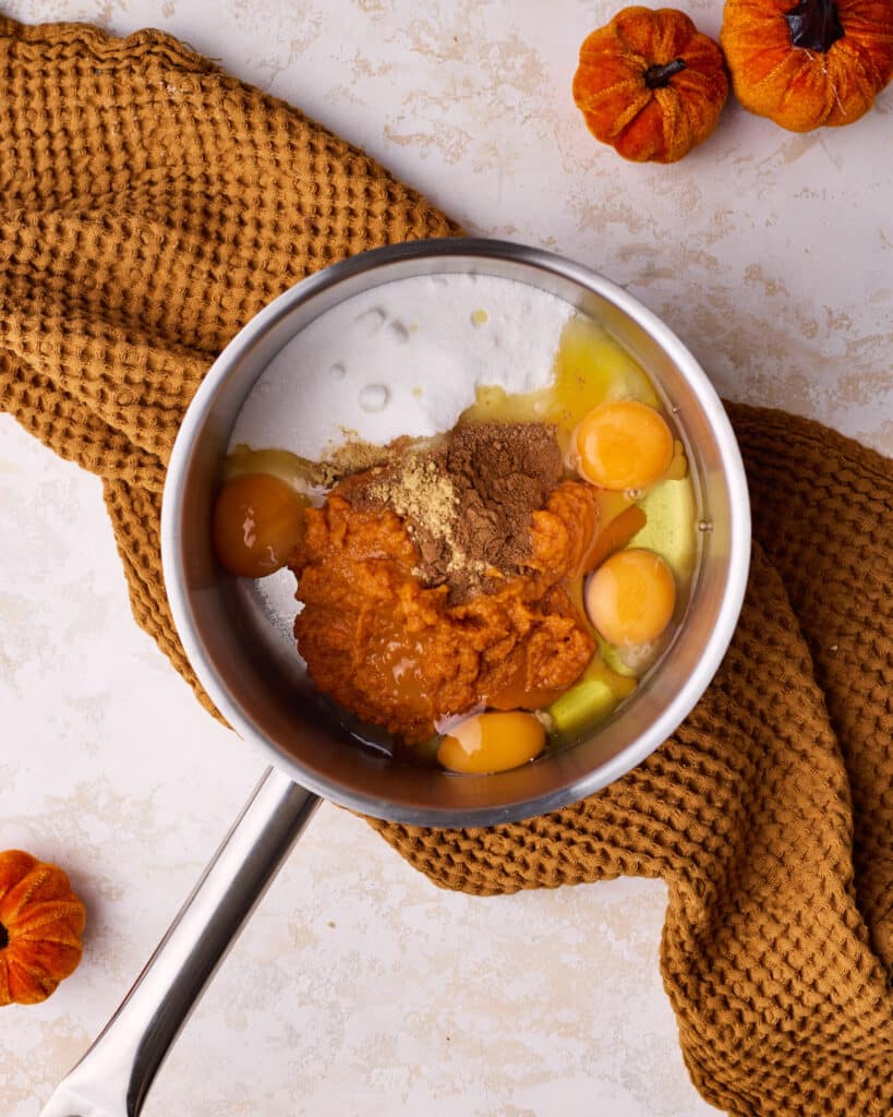 Process shot of making pumpkin curd, adding all the ingredients to a saucepan.