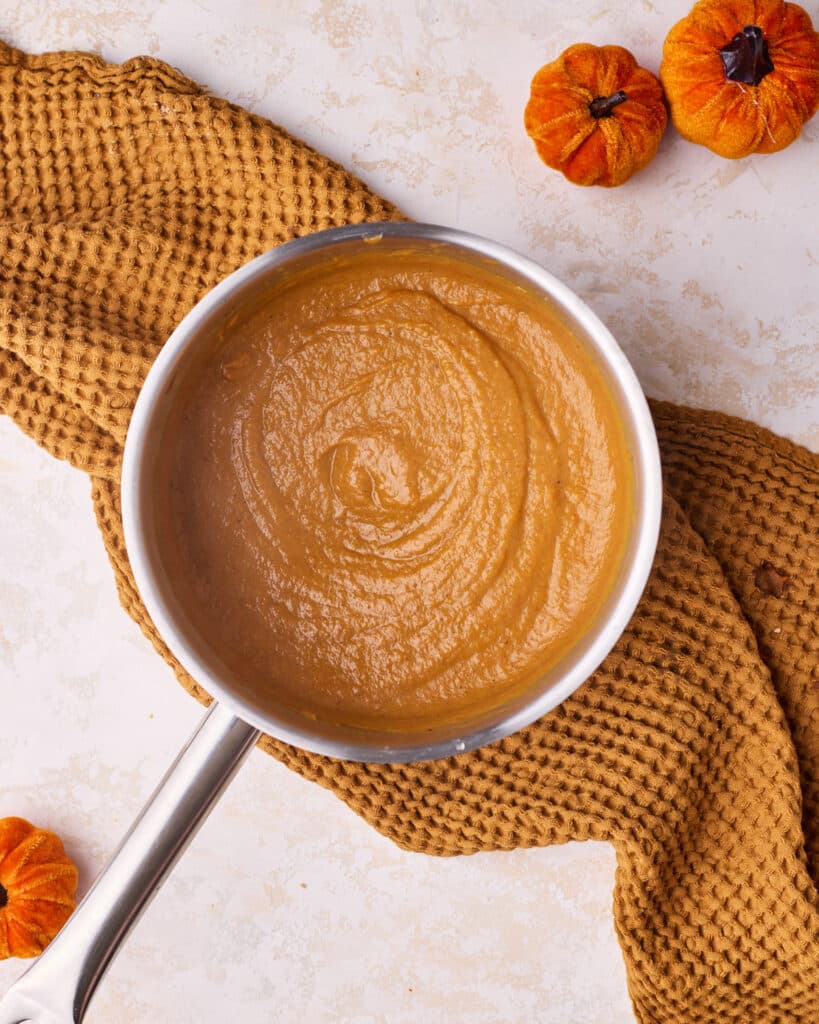 Pumpkin curd thickening in a saucepan as it cooks.