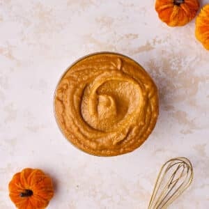 Pumpkin curd in a glass bowl with a swirl shape on top.