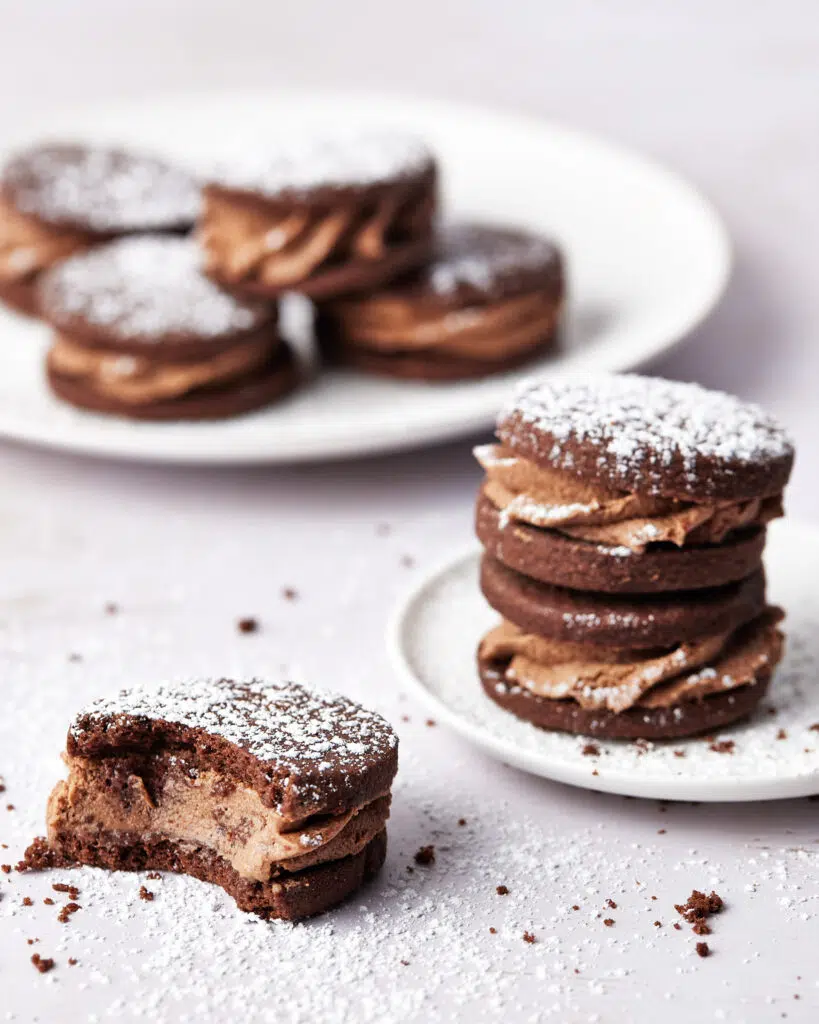 chocolate shortbread filled with whipped ganache, on a plate, with a bite out of it