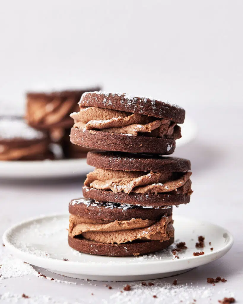 close up of stack of chocolate sandwich cookies with whipped ganache