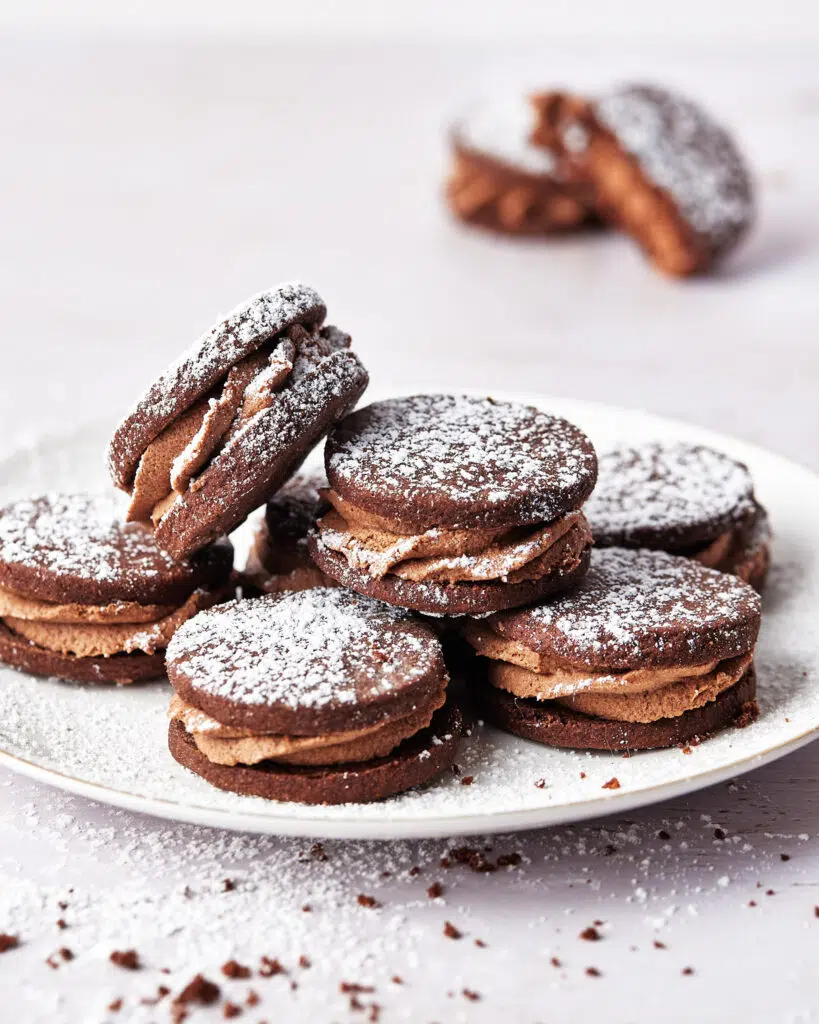 plate of chocolate sandwich cookies with whipped ganache