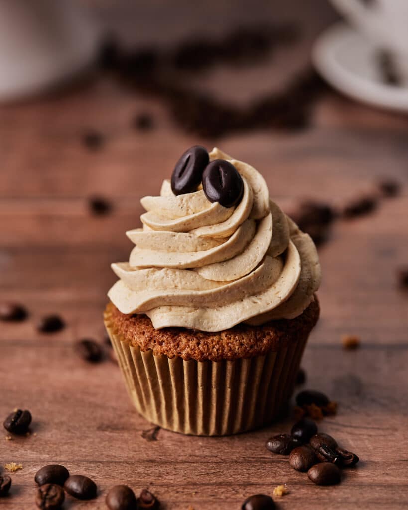 single coffee cupcakes topped with two chocolate coffee beans
