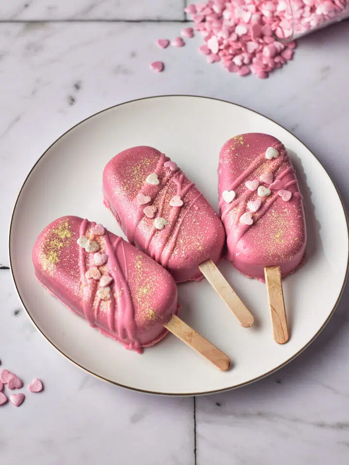 valentines red velvet cakesicles with pink candy melts and heart sprinkles