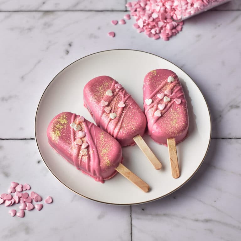 valentines red velvet cakesicles with pink candy melts and heart sprinkles