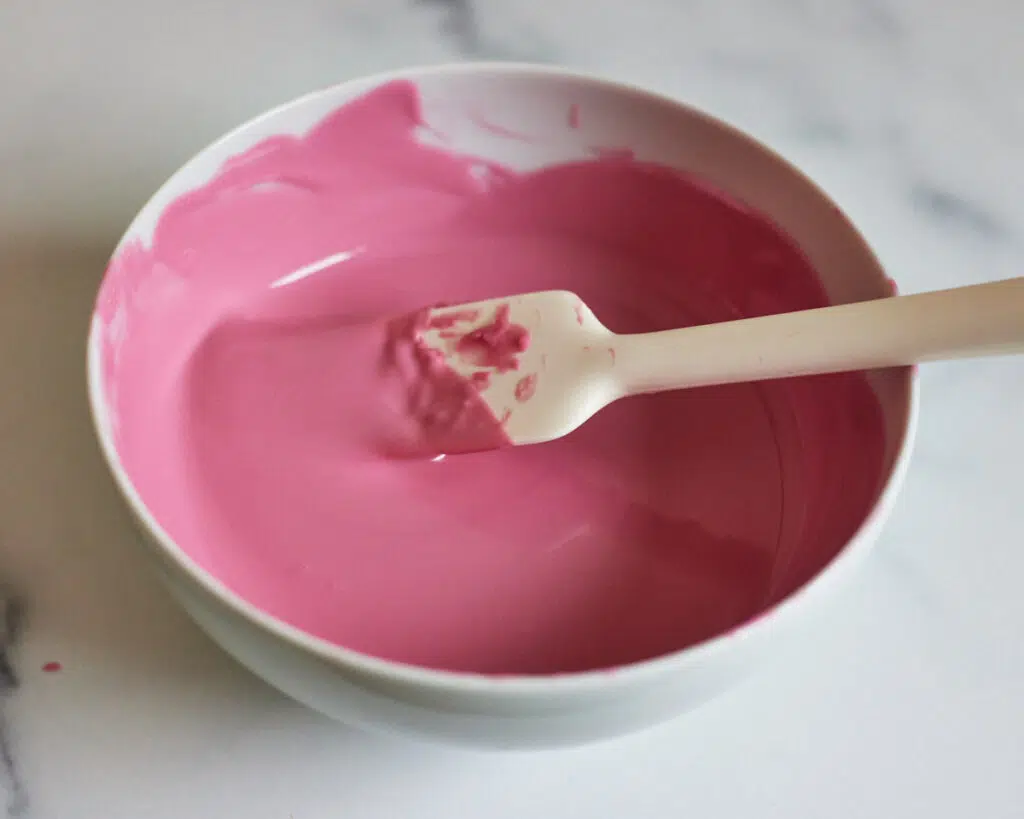 pink candy melts melted in a bowl to make cakesicles