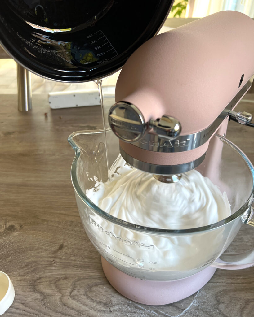 pouring sugar syrup into italian meringue buttercream