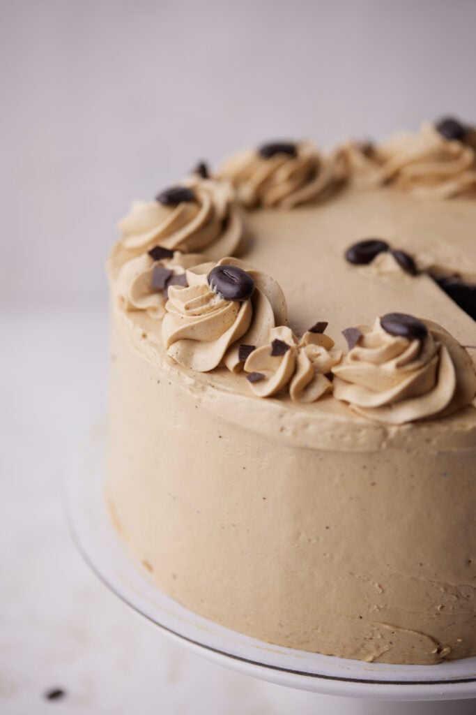 chocolate espresso cake frosted with glossy russian buttercream and decorated with chocolate espresso beans.