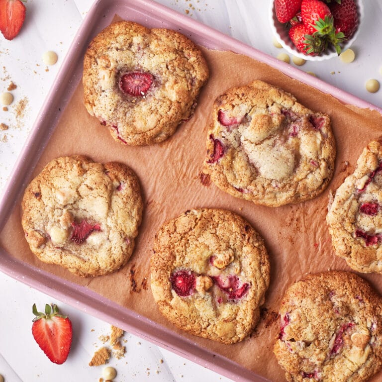 strawberry cheesecake stuffed cookies from above on a pink cookie sheet.