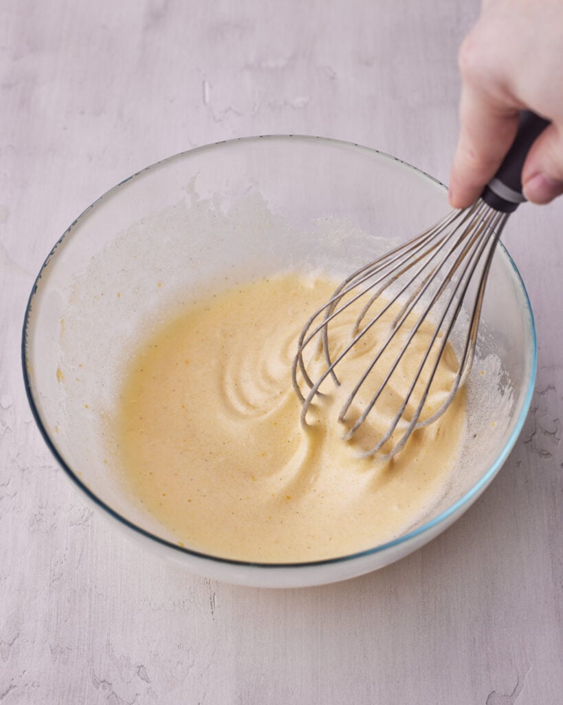 process shot of eggs and sugar being whisked until they are pale and foamy